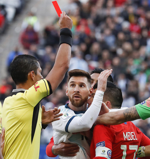 아르헨티나의 리오넬 메시(가운데)가 7일 열린 코파아 메리카 3, 4위전에서 칠레의 가리 메델(오른쪽)과 몸싸움을 벌이는 도중 레드카드를 들어올린 주심을 놀란 표정으로 바라보고 있다. 상파울루=AP 뉴시스