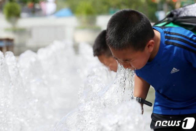 중부지방 낮 최고기온이 30도를 웃도는 무더운 날씨가 지속된 8일 오후 서울 세종대로 광화문광장 바닥분수대를 찾은 아이들이 물놀이를 하며 더위를 식히고 있다. 2019.7.8/뉴스1 © News1