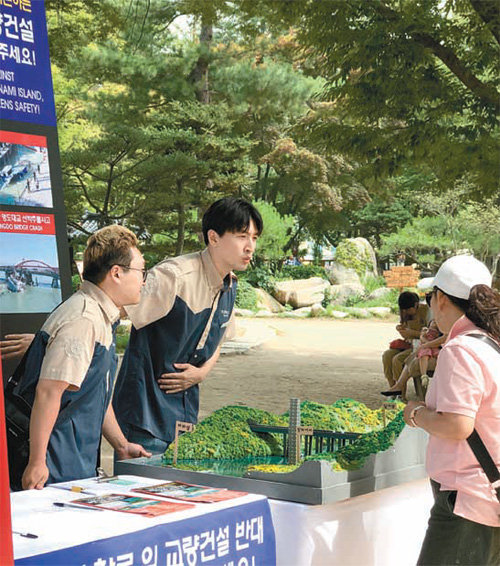 강원 춘천시 남이섬은 섬을 방문한 국내외 관광객을 대상으로 인근 수역의 교량 건설 반대 서명을 받고 있다.