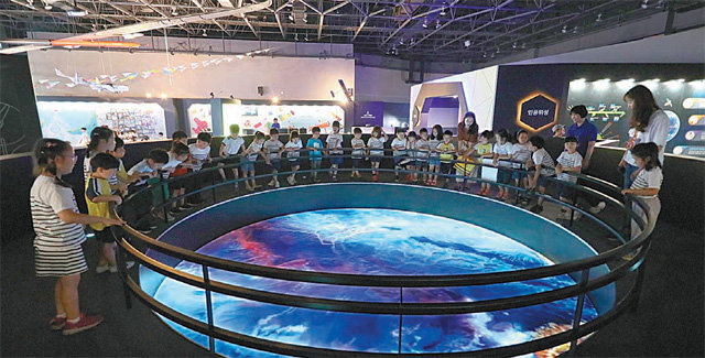 대전 유성구 국립중앙과학관에서 열리는 ‘항공우주특별전’을 찾은 아이들이 위성으로 촬영한 지구의 아름다운 모습을 지켜보고 있다. 한국항공우주연구원 제공