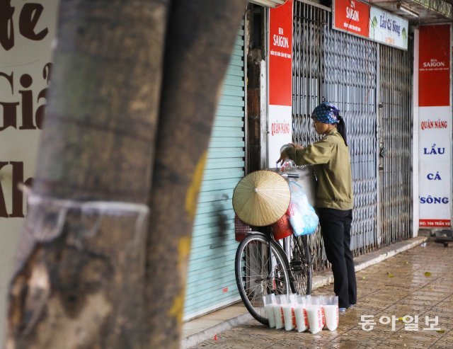 한 여성이 판매할 쌀을 봉지에 담고 있습니다.