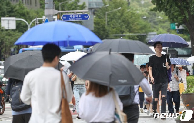전국에 장맛비가 예고된 10일 오후 서울 광화문 네거리에서 비가 내리자 시민들이 발거음을 재촉하고 있다. 2019.7.10/뉴스1 © News1