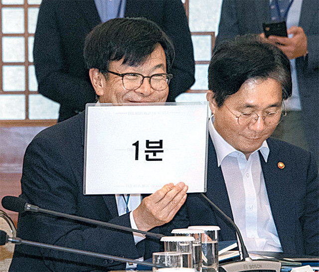 “발언 1분 남았습니다” 김상조 대통령정책실장(왼쪽)이 ‘1분’이라고 적힌 피켓을 들어 발언 마무리를 재촉하고 있다. 청와대사진기자단