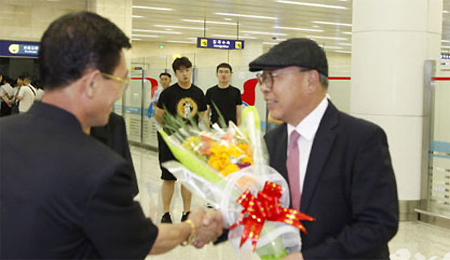 6일 평양국제비행장(순안공항)에 도착한 최덕신의 아들 최인국 씨(오른쪽)가 리명철 북한 천도교 청우당 중앙위원회 부위원장에게서 꽃다발을 받고 있다. 사진 출처 우리민족끼리