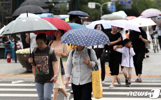 전국에 장맛비가 예고된 10일 오후 서울 광화문 네거리에서 비가 내리자 시민들이 발걸음을 재촉하고 있다. © News1