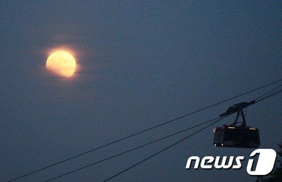 서울 남산타워 케이블카 위로 개기월식 중인 붉은달이 떠오르고 있다. © News1DB