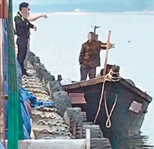 북한 목선이 지난달 15일 삼척항에 정박한 모습. 당시 목선에 탑승했던 북한 어민과 이를 발견한 주민들이 대화를 나누고 있다. 뉴스1