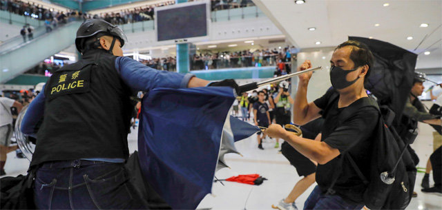 곤봉으로 치고 우산으로 막고… 14일 홍콩의 한 쇼핑몰 안에서 반중 시위대와 경찰이 충돌하고 있다. 경찰의 시위대 해산 촉구에 시위대가 물병, 우산 등을 던지자 경찰은 시위대에 곤봉을 휘두르고 후추 스프레이 등을 뿌렸다. 홍콩=AP 뉴시스
