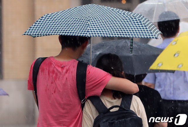 15일 오후 서울 종로구 광화문네거리에서 우산을 쓴 시민들이 내리는 비를 피해 발걸음을 서두르고 있다. © News1