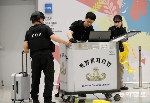 인천공항 폭발물 처리반이 폭발물로 의심되는 여행용 가방의 안전 확인을 마치고 가방을 회수하고 있다.
