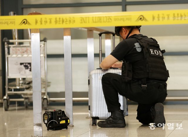 인천공항 폭발물처리반원이 폭발물로 의심되는 여행용가방에 접근해 작업을 하고 있다.