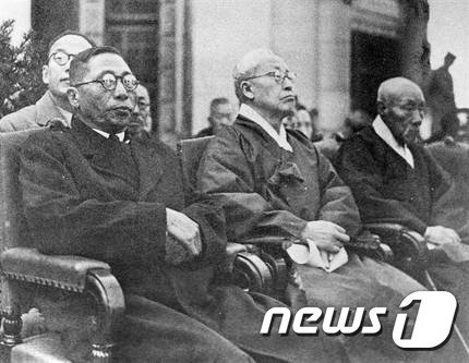 1946년 제27주년 3·1절 기념식에 참석한 김구(왼쪽)와 이승만(가운데)이 해방 이후 처음 맞이한 ‘3·1국경절 제27회 기념식’에서 연단에 나란히 앉아 있다. 김구는 ‘3·1운동’을 ‘3·1대혁명’이라고 불렀지만, 이승만은 1948년 제헌국회 헌법독회 과정에서 ‘혁명’이라는 표현에 찬성하지 않는다는 뜻을 밝혔다.(국가기록원 제공)2019.2.28/뉴스1 © News1