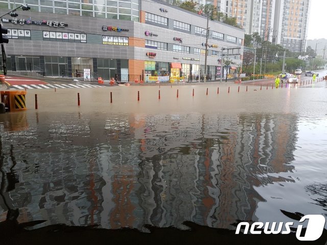 19일 부산지역에 장마전선과 제5호 태풍 ‘다나스’의 영향으로 호우경보가 내려진 가운데 부산 연제구 월륜교차로 일대가 침수됐다. 도로 일대가 물바다로 변한 모습.(부산지방경찰청 제공)© 뉴스1