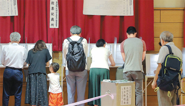 일본 참의원 선거가 치러진 21일 도쿄의 한 투표소에 마련된 기표대에 줄줄이 자리 잡은 유권자들이 기표하고 있다. 이날 오후 8시 출구조사 결과 아베 신조 총리의 자민당이 과반을 확보해 압승을 거뒀다. 도쿄=AP 뉴시스
