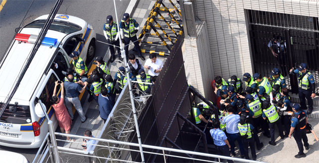 22일 오후 부산 동구 일본 총영사관 내에 진입해 시위를 벌이던 대학생 6명이 연행돼 경찰 차량에 태워지고 있다. 이날 영사관 밖에서 반일 시위를 벌이던 시민단체 회원들이 차량을 막고 경찰에 거세게 항의하고 있다. 부산=뉴시스