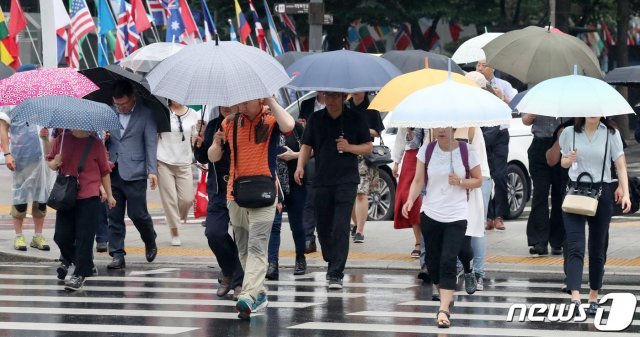 서울지역에 비가 내린 24일 오전 서울 종로구 광화문네거리에서 우산을 쓴 시민들이 출근길 발걸음을 재촉하고 있다. 2019.7.24/뉴스1 © News1