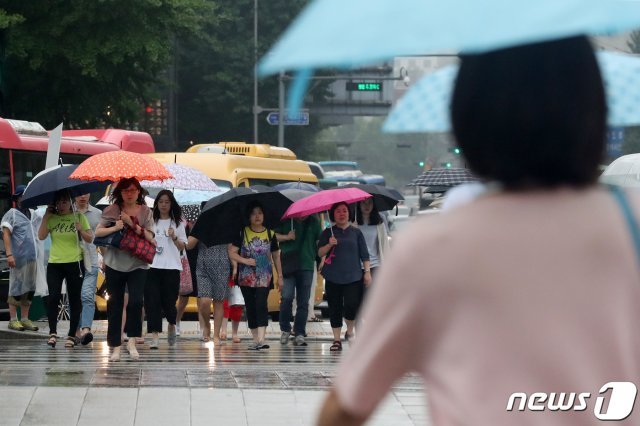 서울지역에 비가 내린 24일 오전 서울 종로구 광화문네거리에서 우산을 쓴 시민들이 출근길 발걸음을 재촉하고 있다. © News1