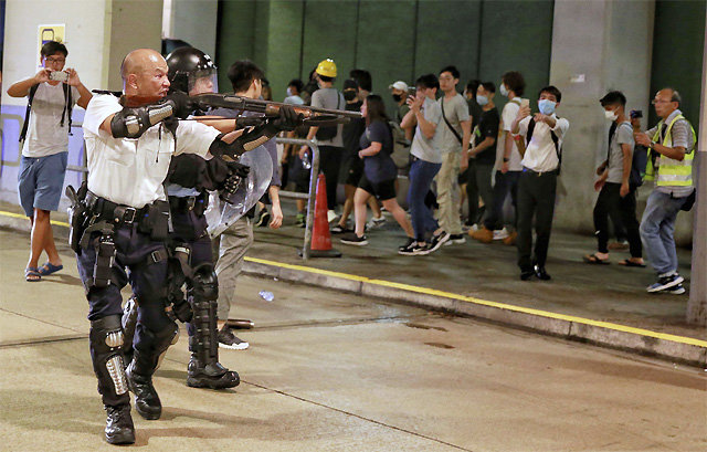 시위대 겨냥한 총구 지난달 30일 홍콩 쿠이충 
경찰서 인근에서 경찰이 송환법 반대 시위대를 향해 총을 겨누고 있다. 경찰은 지난달 28일 시위 당시 체포된 시위 참가자 49명 중
 44명을 폭동 혐의로 기소한다고 이날 밝혔다. 경찰 발표 이후 시위대 수백 명이 쿠이충 경찰서 앞에 모여 경찰의 기소 방침을 
비난하고 구금된 시민 석방을 요구했다. 홍콩=AP 뉴시스