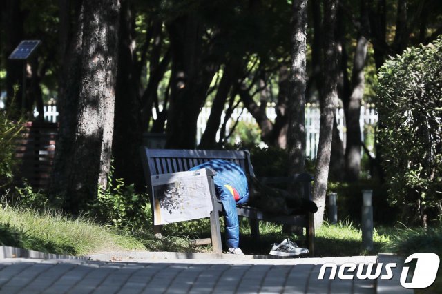 서울 종로구 세종로 공원에서 한 노인이 길거리 벤치에 누워 잠을 청하고 있다. 2018.10.2/뉴스1 DB © News1