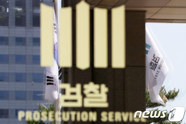 서울 서초구 서울중앙지검 청사 검찰 로고 뒤로 펄럭이는 태극기와 검찰 깃발이 비춰 보이고 있다.  News1