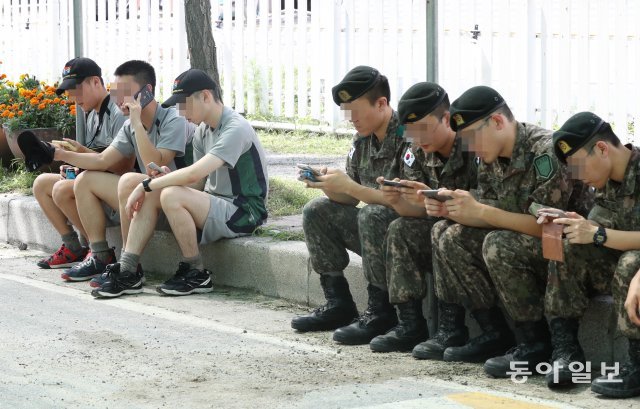 바쁘다 바빠. 평일 오후 2시경 토마토 축제 현장을 찾은 군 병사들이 휴대폰을 사용하는 모습.