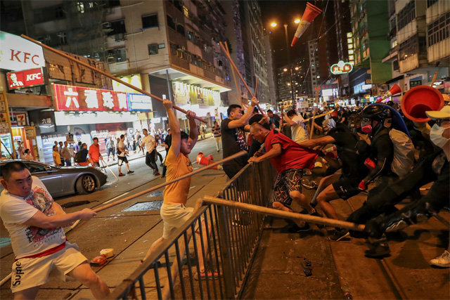 5일 홍콩 도심에서 바리케이드 왼쪽에 있는 남성 몇 명이 반대편의 송환법 반대 시위대를 각목으로 구타하고 있다. 중국은 6일 홍콩
 반중국 시위대를 향해 “불장난을 하면 타 죽는다”고 강력 경고했다. 홍콩 경찰은 이날 5, 6일 이틀간 시위대 148명을 
체포했다고 밝혔다. 홍콩=AP 뉴시스
