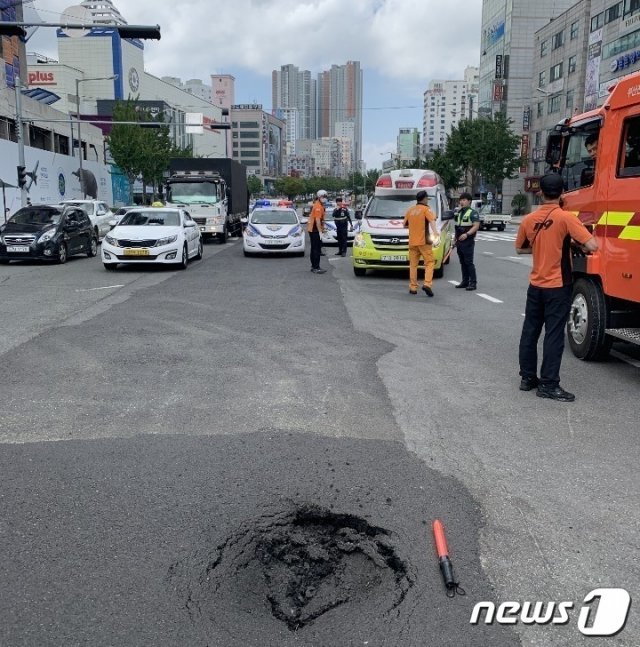 7일 오전 8시30분쯤 부산 남구에 있는 성지고등학교~우암동 방향 도로에서 지름 약 60cm의 포트홀이 발생, 경찰과 소방당국이 현장을 수습하고 있다.(부산지방경찰청 제공)© 뉴스1