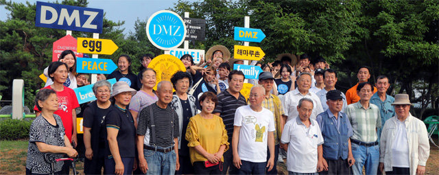 최근 경기 파주시 DMZ해마루촌에서 ‘디자인예술마을 만들기’ 봉사활동을 펼친 동서대 학생들이 마을 주민들과 함께 사인조형물 앞에서 기념촬영을 하고 있다. 동서대 제공