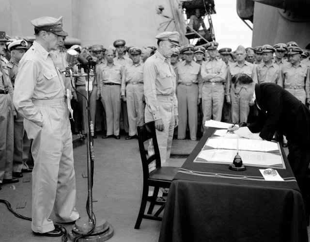 태평양전쟁에서 패전한 뒤 1945년 9월 2일 일본 도쿄만에 정박한 미군 전함 미주리호 위에서 항복 문서에 서명하는 시게미쓰 마모루 일본 외무대신. 맥아더 장군(왼쪽 마이크 앞 인물)과 미군 장병들이 지켜보고 있다. 동아일보DB