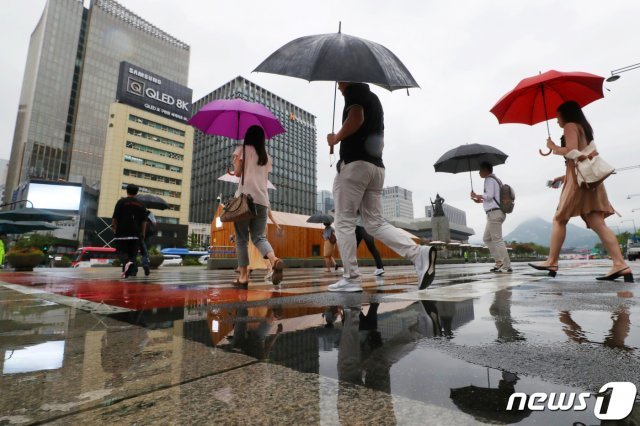 12일 오전 서울 종로구 광화문네거리에서 우산을 쓴 시민들이 출근길 발걸음을 재촉하고 있다. 기상청은 이날 제9호 태풍 ‘레끼마’(Lekima)의 영향으로 전국이 대체로 흐리고 서울·경기와 강원 영서 북부 등에는 비가 오겠다고 밝혔다. 2019.8.12/뉴스1 © News1