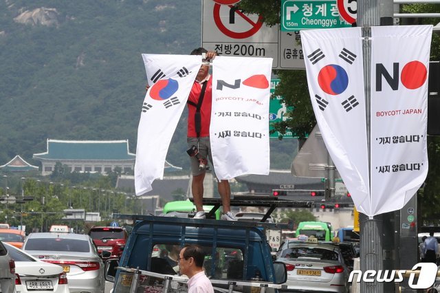 6일 오전 서울 중구 세종대로 일대에서 중구청 관계자들이 태극기와 ‘노 재팬’ 배너깃발을 설치하고 있다. © News1