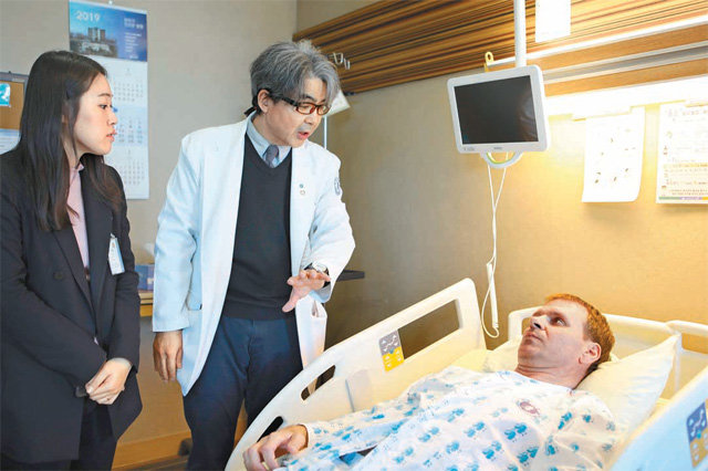 최선근 인하대병원 교수(가운데)가 직장암 수술을 받은 러시아인 수클리안 데니스 씨(오른쪽)와 수술 이후의 몸 상태에 대해 이야기를 나누고 있다. 인하대병원 제공