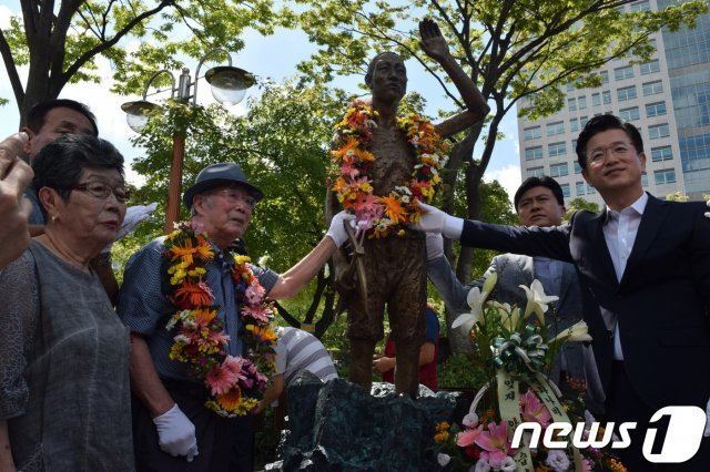 강제 징용 피해자인 김한수씨(102)가 허태정 대전시장과 함께 대전강제징용노동자상을 보며 기념사진 촬영을 하고 있다. © 뉴스1