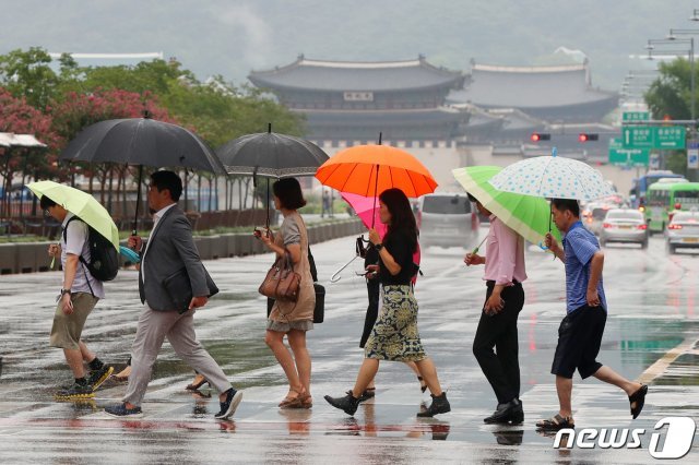 12일 오전 서울 종로구 광화문네거리에서 우산을 쓴 시민들이 출근길 발걸음을 재촉하고 있다. 기상청은 이날 제9호 태풍 ‘레끼마’(Lekima)의 영향으로 전국이 대체로 흐리고 서울·경기와 강원 영서 북부 등에는 비가 오겠다고 밝혔다. © News1