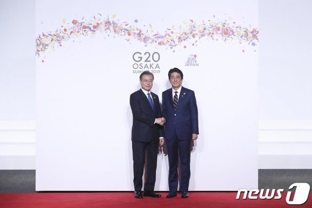 문재인 대통령이 인텍스 오사카에서 열린 G20 정상회의 공식환영식에서 의장국인 일본 아베 신조 총리와 악수하고 있다. (청와대 제공)