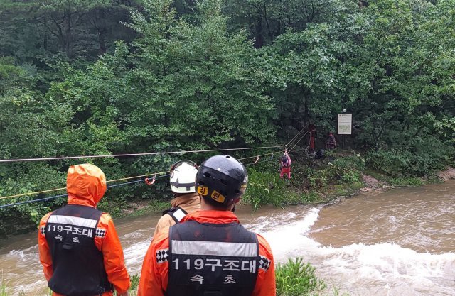 15일 오전 11시 44분경 고성군 미시령계곡에서 119대원들이 폭우로 불어난 물에 고립된 등산객 2명을 구조하고 있다.