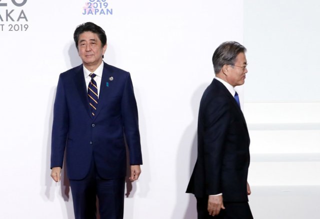 문재인 대통령이 6월 28일 일본 인텍스 오사카에서 열린 G20 정상회의 공식 환영식에서 의장국인 일본 아베 신조 총리와 인사한 뒤 이동하고 있다. [청와대 사진기자단]