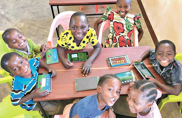 에누마가 개발한 킷킷스쿨이 탑재된 태블릿PC를 사용하며 즐거워하는 아프리카 아이들. 에누마 제공