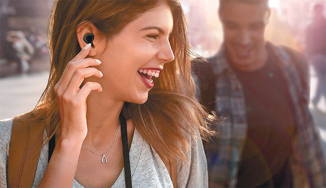 무선 이어폰 갤럭시 버즈를 착용한 한 여성이 통화를 하며 웃고 있다. 최근 무선 이어폰에 다양한 기능이 늘면서 판매도 급증세다. 삼성전자 제공