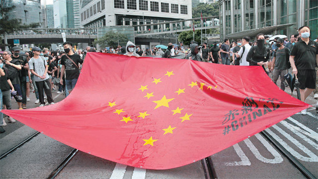 ‘차이나치’ 깃발 든 홍콩 反中시위대 지난달 31일(현지 시간) 홍콩 반중 시위대가 ‘차이나치(China+Nazi)’로 불리는 대형 깃발을 들고 도심을 행진하고 있다. 중국 공산당을 독일 나치에 비유한 이 깃발은 중국 국기인 오성홍기의 빨간색 바탕 위에 역시 오성홍기에 있는 노란 별을 나치의 십자가 문양 형태로 배열했다. 시위대는 1일에도 경찰과 격렬하게 충돌해 홍콩 공항으로 가는 공항철도 운행이 중단됐다. 홍콩=AP 뉴시스