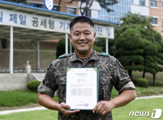 육군 11사단 화생방지원대에 근무하고 있는 이대일(30) 중사가 세이브 더 칠드런 후원회원 확인서를 들고 기념사진을 찍고 있다. (11사단 제공) 2019.9.9/뉴스1 © News1
