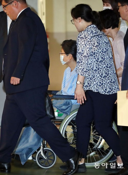 박근혜 전 대통령이 호송차에서 내려 휠체어를 타고 마스크를 착용한 채 입원실로 향하고 있다. 사진=전영한 기자 scoopjyh@donga.com