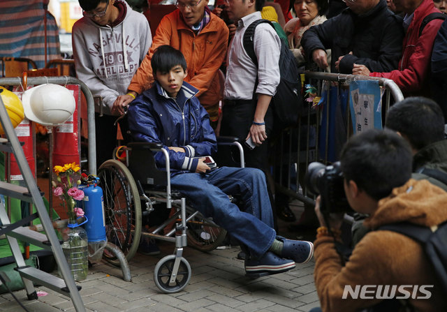 2014년 12월 5일 조슈아 웡이 홍콩 정부청사 밖에서 단식 투쟁을 하던 중 휠체어에 앉아 기자회견을 하는 모습. / 뉴시스