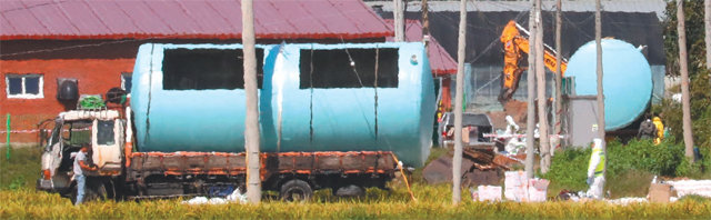 매몰 준비 분주 19일 오전 아프리카돼지열병(ASF)이 발병한 경기 연천군의 한 돼지 축사에서 공무원 등 관계자들이 돼지 매몰용 탱크를 설치하고 있다. 연천=뉴시스