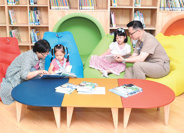 19일 개관한 경남 창원시 진해구 ‘바다마을 작은도서관’에서 해군 가족이 독서를 즐기고 있다. 작은도서관만드는사람들 제공
