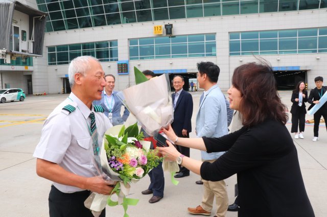 20일 인천국제공항에서 에어서울 서정수 기장이 마지막 비행을 마치고 한 직원이 꽃다발을 주고 있다. 에어서울 제공