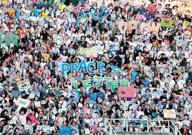 18일 오후 경기 수원시 팔달구 우만동 수원월드컵경기장에서 열린 ‘9·18 평화 만국회의 제5주년 기념식’에서 ㈔하늘문화세계평화광복(HWPL) 회원들이 피켓을 들고 환호하고 있다.