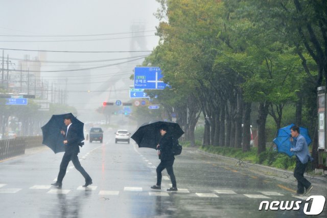 북상 중인 제17호 태풍 타파 간접영향권에 들어간 22일 경북 포항시 남구 포항운동장 앞 도로를 건너는 시민들이 강풍으로 인해 힘겹게 발걸음을 옮기고 있다. © News1