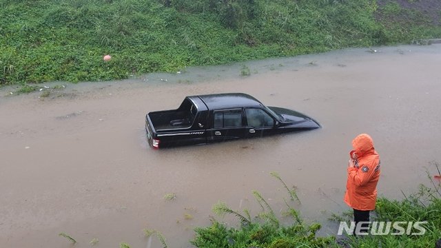 22일 오후 제주시 애월읍 고성리 평화로 보조도로에서 쏟아진 빗물에 차량 한 대가 고립돼 구조를 기다리고 있다. 사진=뉴시스