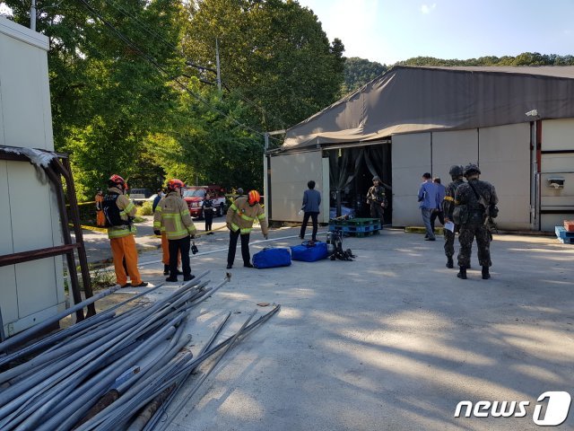 군과 소방서 관계자들이 헬기에서 콘테이너가 떨어져 내리면서져 부서진 공장 가건물을 살펴보고 있다.(독자제공 )© News1